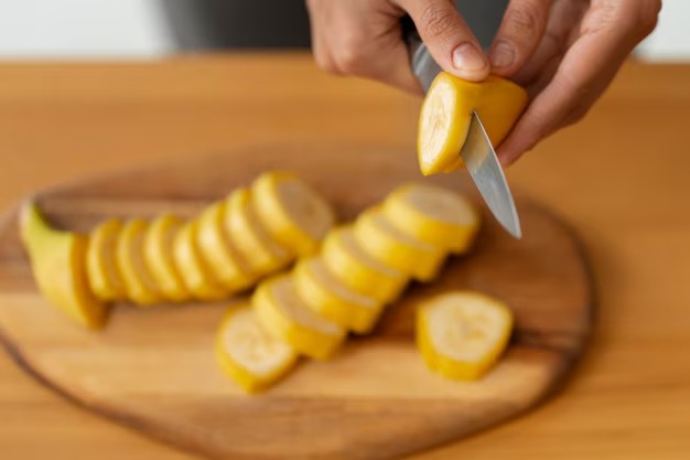 Pessoa cortando banana com casca