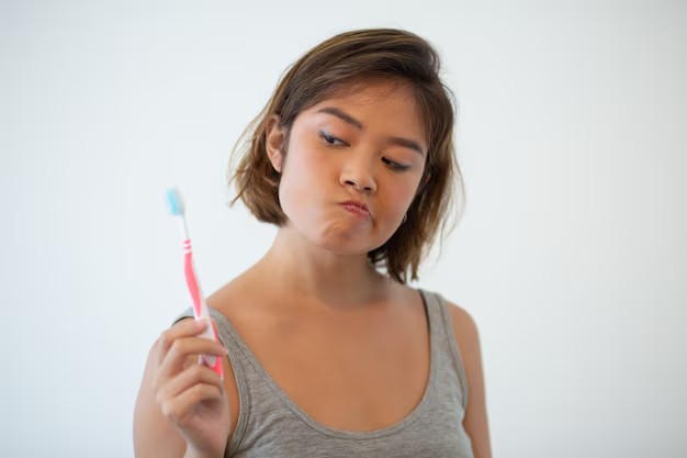 Mulher com escova de dente nas mãos